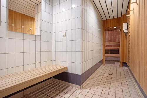 a tiled bathroom with a bench and a closet at Haus A Cappella B6 in Binz