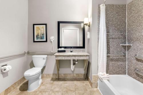 a bathroom with a toilet and a sink and a shower at Comfort Suites at Katy Mills in Katy