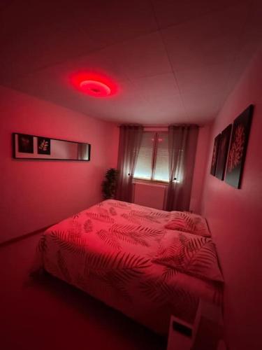 - une chambre rose avec un lit rouge dans l'établissement Luxury Room - Havre de paix avec jacuzzi privé, à Bar-le-Duc