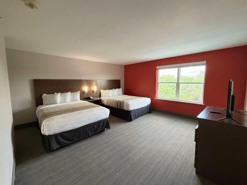 a hotel room with two beds and a window at Country Inn & Suites by Radisson, Harlingen, TX in Harlingen