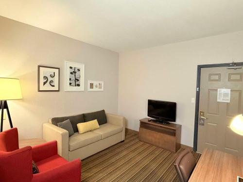 a living room with a couch and a tv at Country Inn & Suites by Radisson, Harlingen, TX in Harlingen
