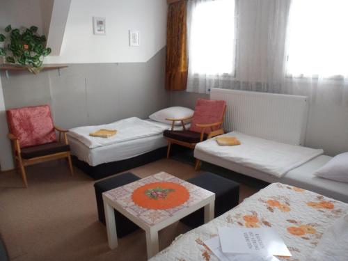 a room with two beds and a table and chairs at Pension Mikulka in Mikulov v Krušných Horách