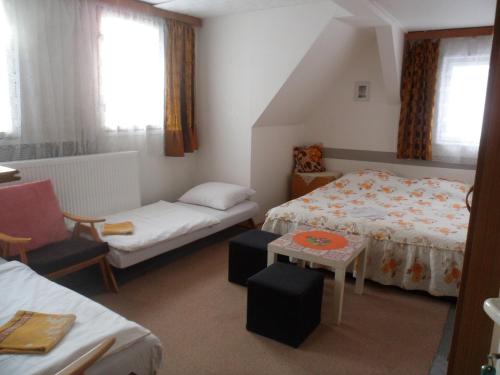 a small room with two beds and a chair at Pension Mikulka in Mikulov v Krušných Horách