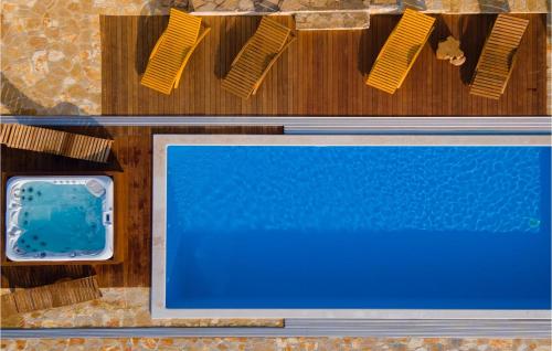 an overhead view of a swimming pool with two chairs at Villa Julijud in Brajkovići