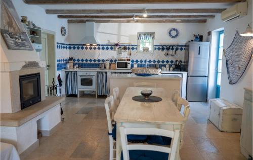 a kitchen with a table and chairs and a kitchen with white appliances at Villa Julijud in Brajkovići