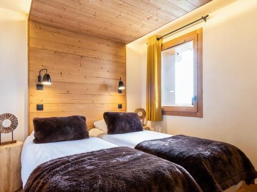 deux lits dans une chambre aux murs en bois dans l'établissement Appartement de luxe calme Les Saisies - 6 pers, SPA & parking privé - FR-1-810-3, à Hauteluce