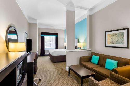 a hotel room with a bed and a living room at Comfort Suites at Katy Mills in Katy