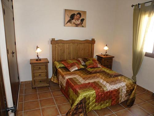 a bedroom with a bed and two night stands with lamps at Villa Marta Clara in Conil de la Frontera