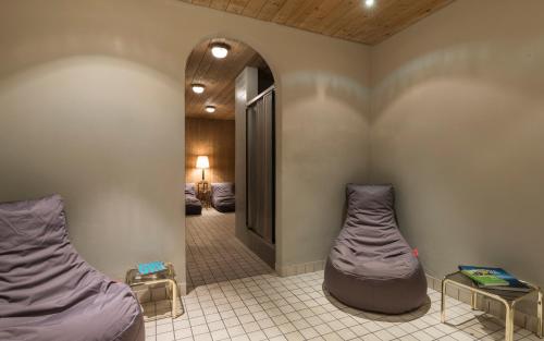 a room with two beds and a hallway at Boutique Hotel Am Park in Valdaora