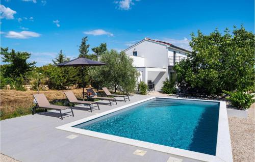 a swimming pool with chairs and an umbrella next to a house at Villa Black Wood in Zadar