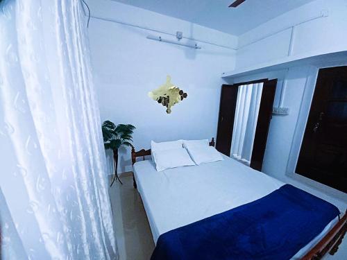 a bedroom with a bed and a window at Alappuzha Family Vacation Villa - LAYANILA in Alleppey