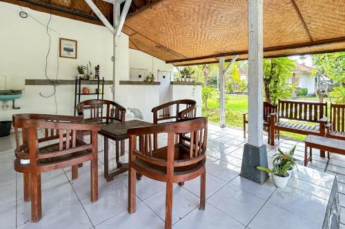 a dining room with a table and chairs at Hepi Bungalow Lovina Mitra RedDoorz in Panji