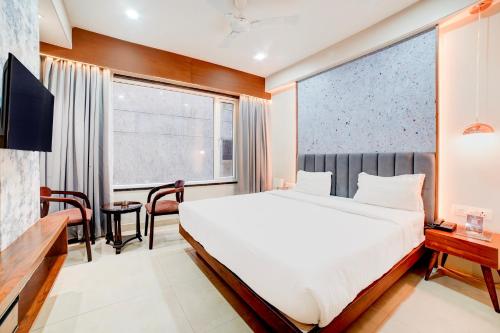 a bedroom with a large bed and a desk at Palette Patel Nagar in Bhopal