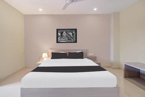 a white and black bed in a white room at Super Collection O ISBT in Guwahati