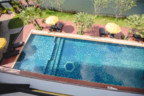 an overhead view of a swimming pool with chairs and umbrellas at Phuengluang Riverside Hotel Chanthaburi in Chanthaburi