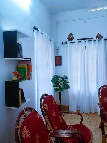 a living room with two chairs and a window at Alappuzha Family Vacation Villa - LAYANILA in Alleppey