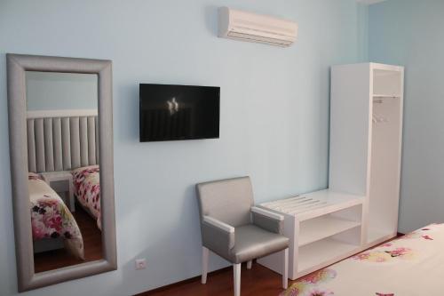 a bedroom with a mirror and a chair and a tv at Grande Oceano Guest House in Porto