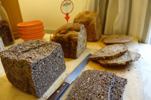 une table avec du pain sur une planche de découpe avec un couteau dans l'établissement La Ferme des Isles, à Authouillet