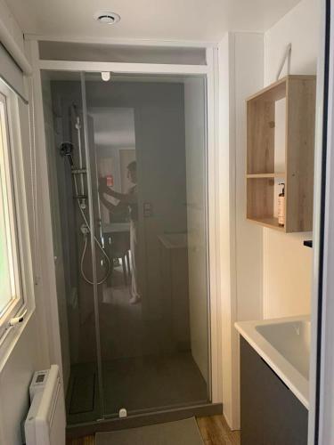 un homme debout dans une douche dans la salle de bains dans l'établissement Le Domaine de Kerlann, à Pont-Aven