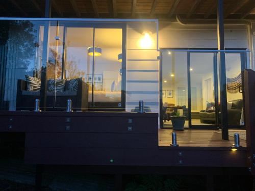 a living room with glass doors and a couch at Incredible mountain & sea views in Mapua