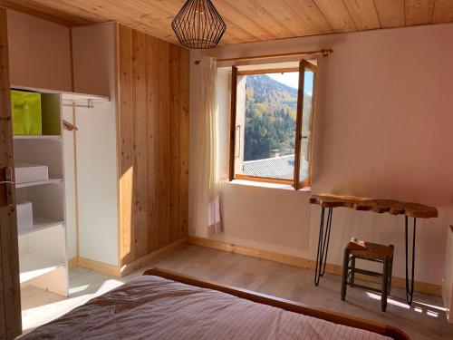 a bedroom with a bed and a window at Les Astrances, logement dans une maison de village in LʼHuez