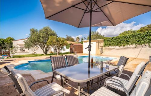 a patio with a table and chairs and a pool at Lovely Home In Chiclana De La Fronter in Chiclana de la Frontera