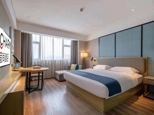Una habitación de hotel con una cama grande y un escritorio. en Echarm Hotel Jiangnan Wanda Baisha Avenue Branch, en Nanning