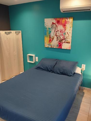 une chambre bleue avec un lit et un tableau mural dans l'établissement Bedroom Agde 34300, à Agde