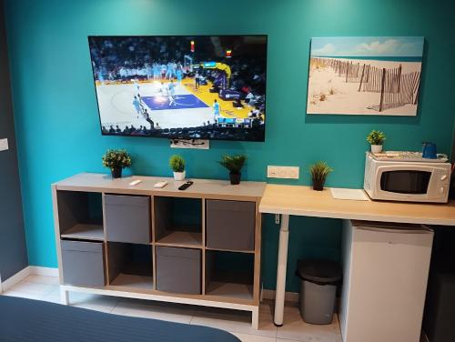 una scrivania con forno a microonde e una TV a parete di Bedroom Agde 34300 ad Agde