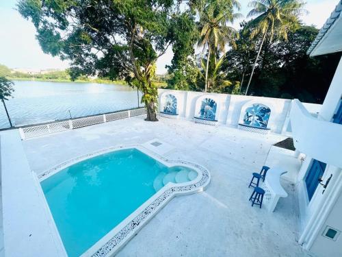a swimming pool on a patio next to a body of water at The Tranquilite' in Anuradhapura