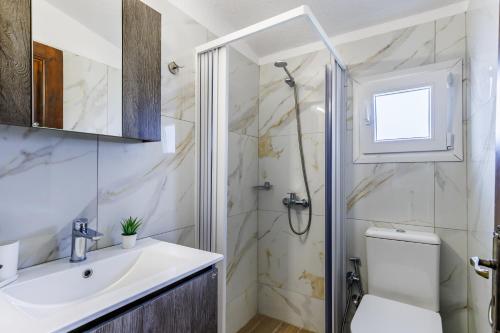 a bathroom with a sink and a toilet and a shower at Studios Elpiniki in Skopelos Town
