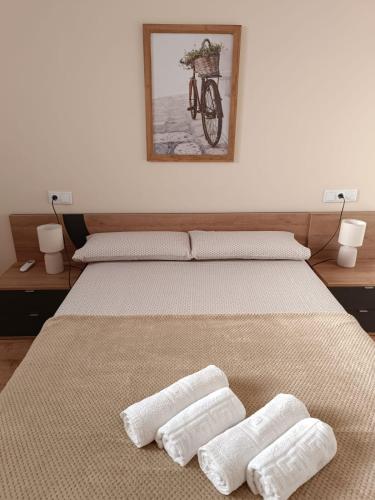 a bedroom with a bed with two white towels on it at Apartamento Barbadillo - Redmansur in Cáceres
