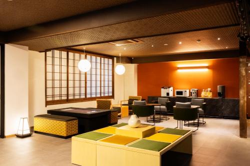 a lobby with a waiting area with tables and chairs at Yusai Bekkan in Minamioguni