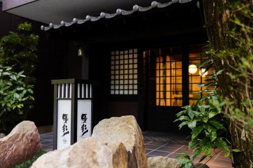 a house with a lantern and a rock in front of it at Yusai Bekkan in Minamioguni