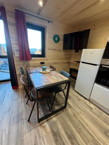 a dining room with a table and a refrigerator at Les appartements de Makalu Val Thorens in Val Thorens