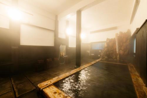 a room with a pool of water in a building at Yusai Bekkan in Minamioguni