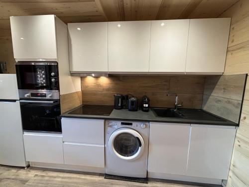 a kitchen with a washing machine and a washer at Les appartements de Makalu Val Thorens in Val Thorens