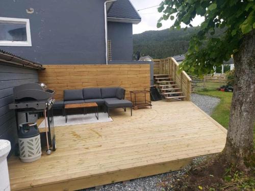 una terraza con sofá y parrilla en una casa en Aalesund Guesthouse 4 Bedroom, en Ålesund