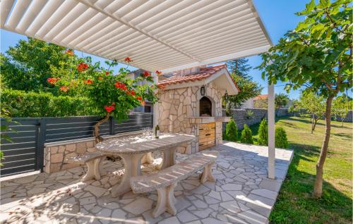 a patio with a table and a pizza oven at Beautiful Home In Gornji Vinjani in Gornji Vinjani