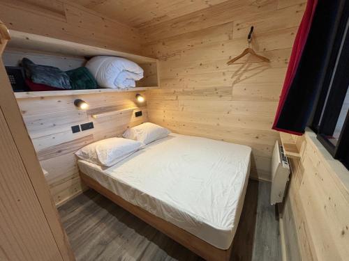a small room with a bed in a wooden cabin at Les appartements de Makalu Val Thorens in Val Thorens