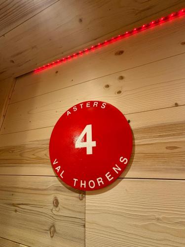 a red sign on a wooden wall with lights at Les appartements de Makalu Val Thorens in Val Thorens