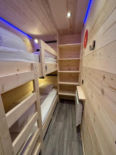 a room with two bunk beds in a log cabin at Les appartements de Makalu Val Thorens in Val Thorens