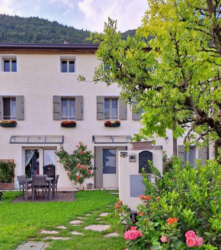 a large white house with a table and chairs in the yard at Casa Paola in Borso del Grappa