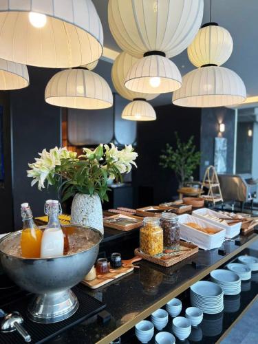 a buffet line with plates of food on a table at M Village Hotel Da Nang Centre - Free Laundry and Kitchen in Da Nang