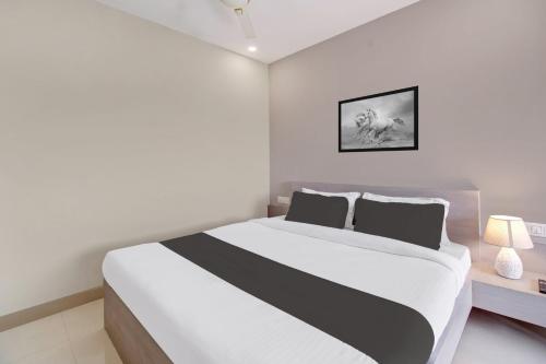 a bedroom with a white and black bed and a lamp at Super Collection O ISBT in Guwahati