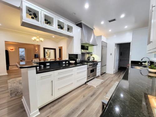 a kitchen with white cabinets and black counter tops at 3 bedroom top story apartment near Pico blvd in Los Angeles