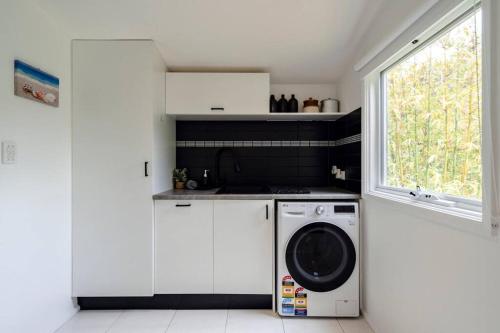 a kitchen with a washing machine and a window at Bellarine Retreat - Pet friendly in Portarlington