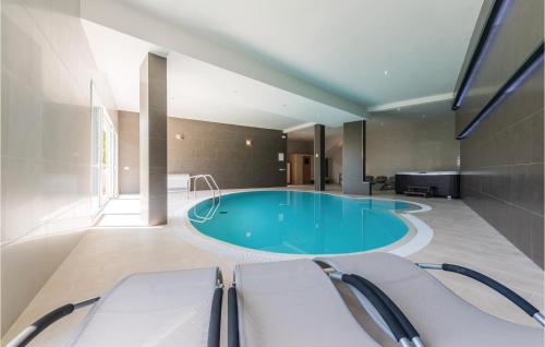 una gran piscina en una habitación con mesa y sillas en Lovely Home In Solin With Sauna, en Solin