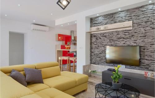 a living room with a yellow couch and a brick wall at Villa Imela in Pula