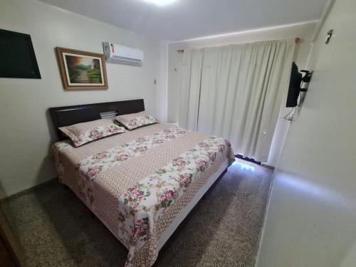 a small bedroom with a bed and a window at Resort Aquaville Apartmento in Aquiraz